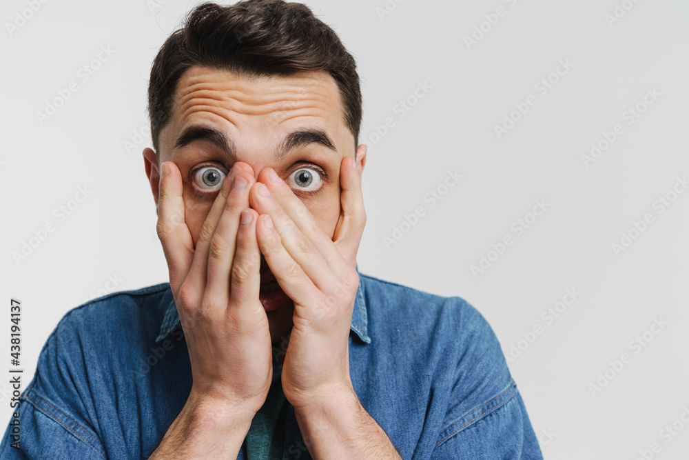 Young brunette man dressed denim shirt covering his face Young brunette man dressed denim shirt covering his face