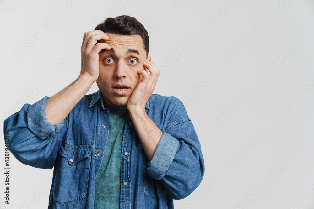Young brunette man dressed denim shirt covering his face Young brunette man dressed denim shirt covering his face