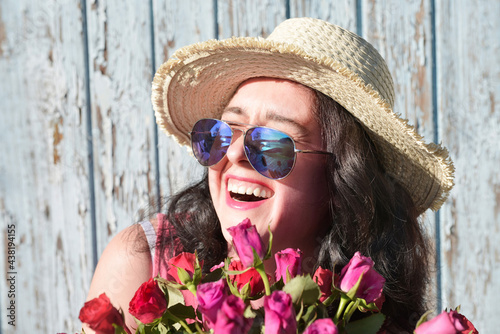 Happy laughing woman with roses in sunglasses