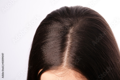 Close-up of female parting hair roots top view. photo