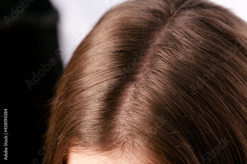 Obraz na plátně Close-up of female parting hair roots top view.