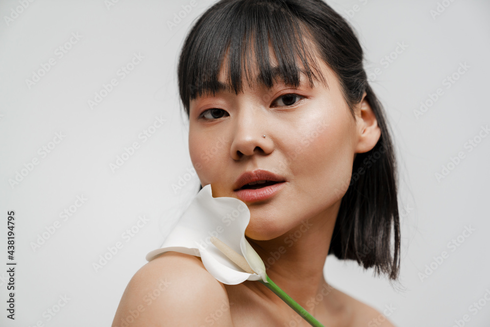 Young asian shirtless woman with piercing posing wit flower - obrazy, fototapety, plakaty 