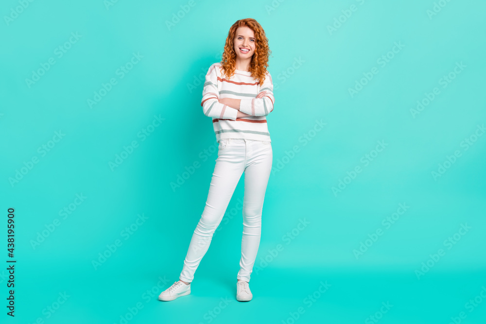 Full length body size view of attractive cheerful girl folded arms posing isolated over bright teal turquoise color background Full length body size view of attractive cheerful girl folded arms posing isolated over bright teal turquoise color background