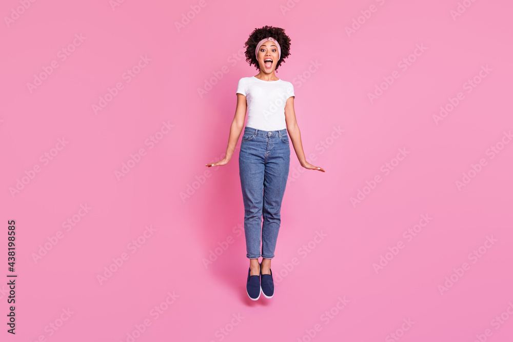 Full length body size photo of childish playful crazy girl happy jumping high isolated pastel pink background Full length body size photo of childish playful crazy girl happy jumping high isolated pastel pink background
