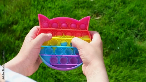 New popular silicone popit toy, baby is playing with it. Rainbow Trendy Pop it fidget toy