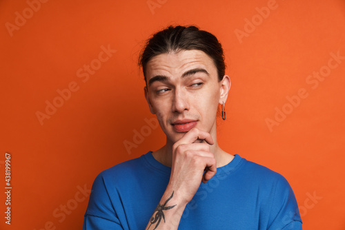 Young white man with earring posing and looking aside