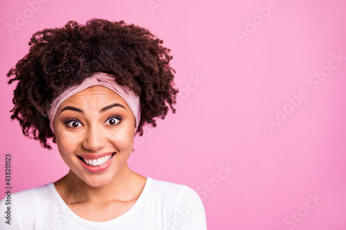Photo of brunette optimistic lady with empty space wear white t-shirt hairband isolated on pastel pink background