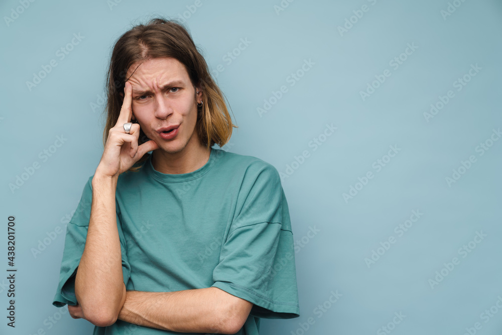 Young white man wearing t-shirt frowning while looking at camera Young white man wearing t-shirt frowning while looking at camera