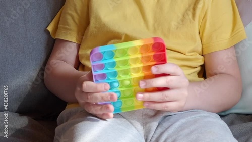 colorful anti-stress sensory fidget push pop it toy in children's hands