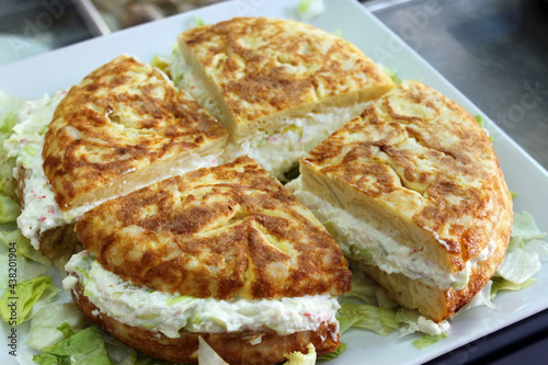 tortilla española de patatas, rellena de ensaladilla rusa