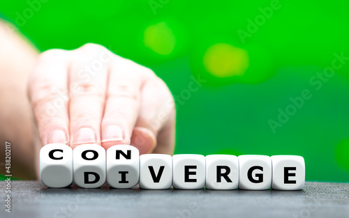 Hand turns dice and changes the word "diverge" to "converge".