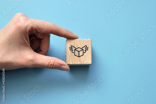 Quick delivery icon on a wooden cube. Symbol of fast delivery of the purchased product