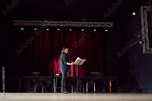 Professional violinist reading sheet music in concert hall photo