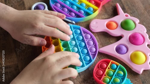 New popular silicone popit toy, baby is playing with it. Rainbow Trendy Pop it fidget toy