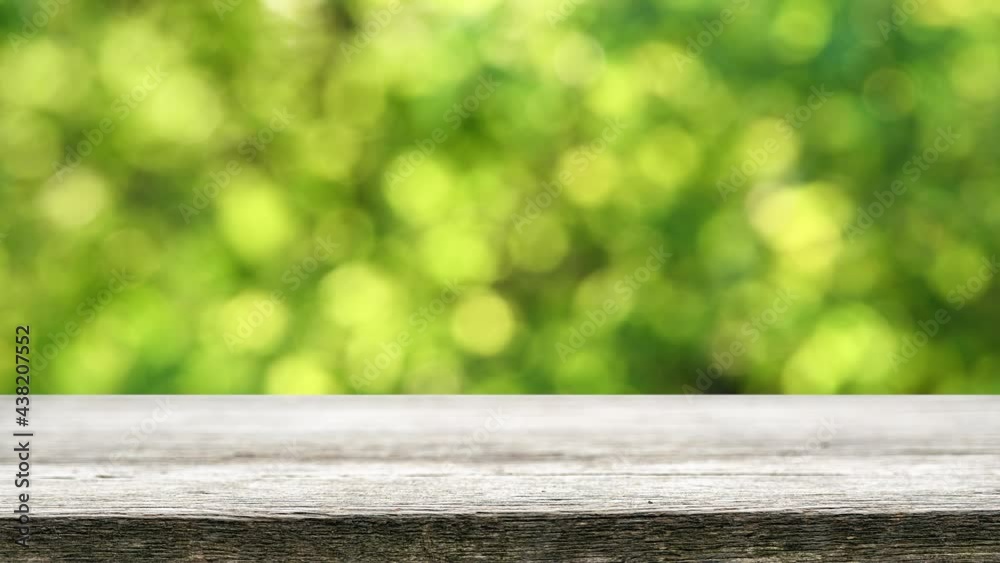 Empty wooden table with fresh green bokeh background