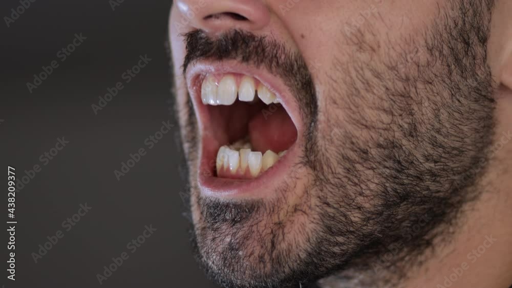 Closeup of bearded man's mouth that screams. Frustration or desperation concept Closeup of bearded man's mouth that screams. Frustration or desperation concept