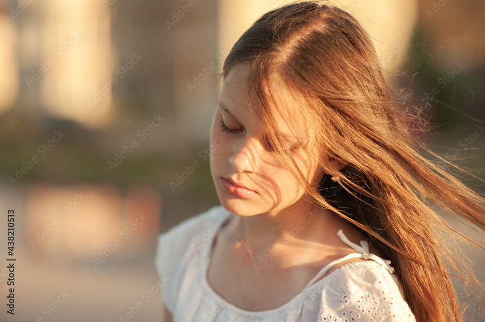 Portrait of a girl with hair developing from the wind at sunset Portrait of a girl with hair developing from the wind at sunset