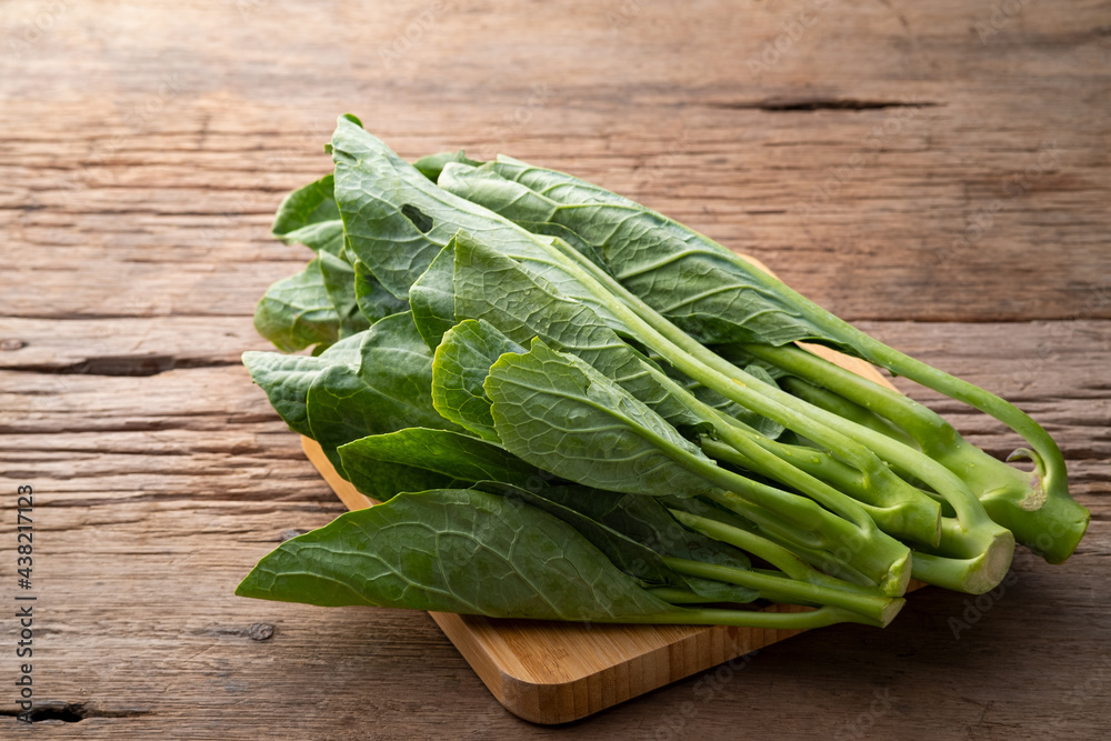 Close up Chinese kale vegetable on wooden plate Close up Chinese kale vegetable on wooden plate