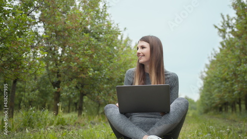 IT specialist working at self isolation outdoors. Women engaging in business or freelance at nature or fresh air at amazing sun light. Girl sitting in park or forest, opening laptop on nature.