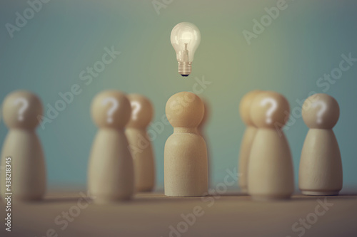Wooden figures of man and people stand with light bulb icon and question mark symbol. Concept creative idea and innovation. Human resource and talent management