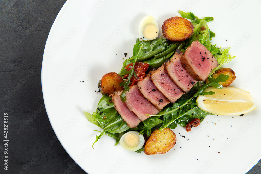 fried tuna on a pad of green beans