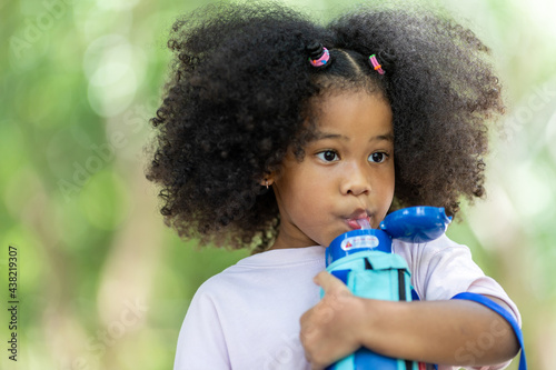 Children holding water plastic bottles and looking before a drink at outdoor. food and drink concept.