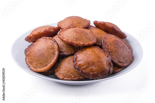 plate of deep fried sri lankan sweet called kevum or kavum, traditional dessert made from rice flour and palm sugar or kithul sugar isolated on white background