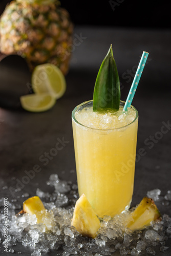 Cocktail with pineapple, coconut and lemon on stone background photo