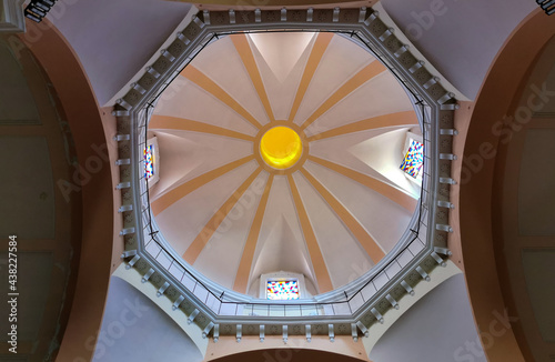 Cupola di una chiesa illuminata dal sole con ballatoio e finestre con vetrate artistiche