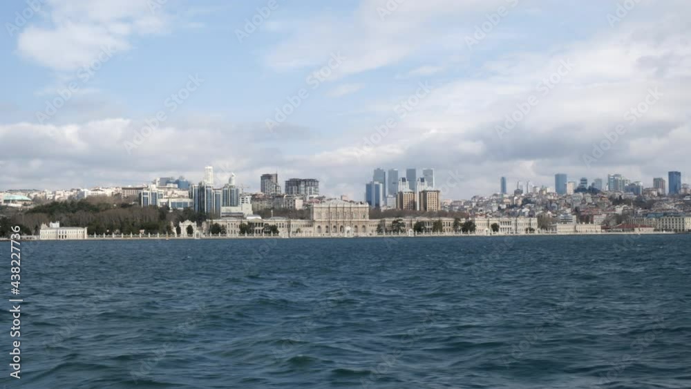 Dolmabahce palace in Istanbul city view from sailing ship along Bosphorus strait. Cityscape modern Istanbul city with boat trip Dolmabahce palace in Istanbul city view from sailing ship along Bosphorus strait. Cityscape modern Istanbul city with boat trip