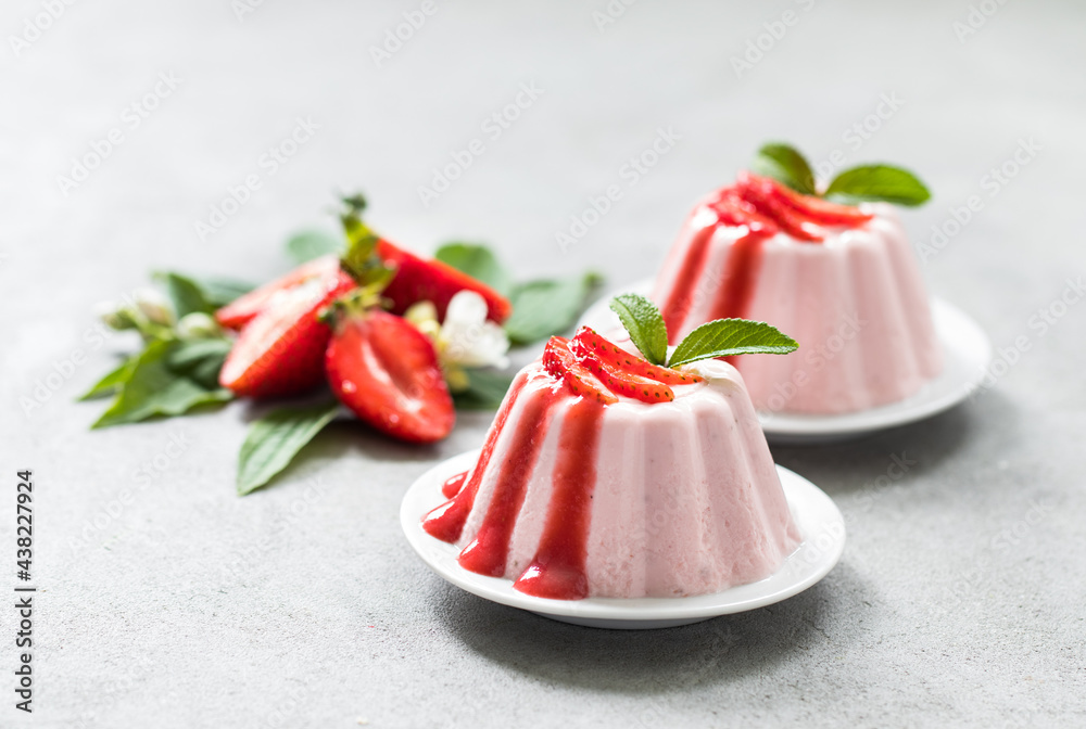 Italian Panna Cotta strawberry with sauce on a plate on a light background Italian Panna Cotta strawberry with sauce on a plate on a light background