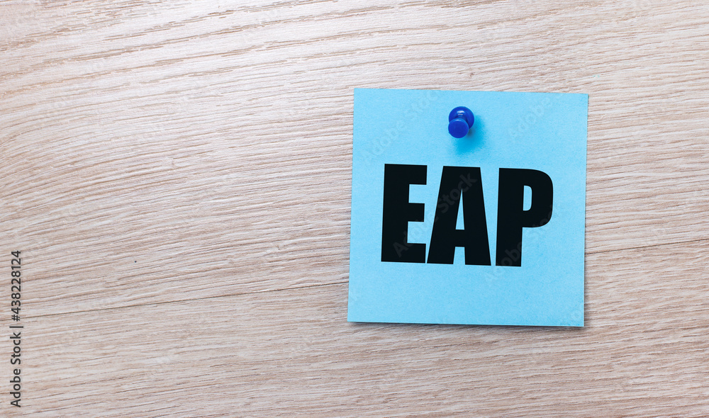 On a light wooden background - a light blue square sticker with the text EAP Employee Assistance Program