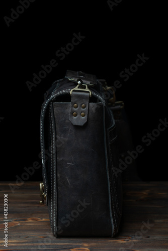 Retro style dark leather messenger bag with rivet straps.