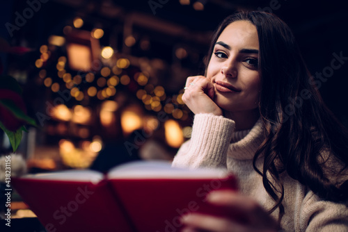 Cheerful lady with book looking at camera
