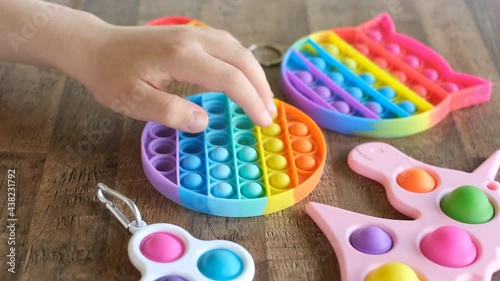 New popular silicone popit toy, baby is playing with it. Rainbow Trendy Pop it fidget toy
