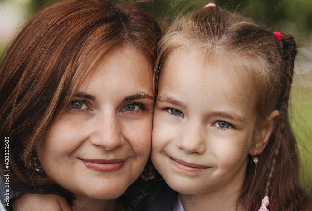 Close-up portrait of a young mother and daughter of school age. happy moments together. Close-up portrait of a young mother and daughter of school age. happy moments together.