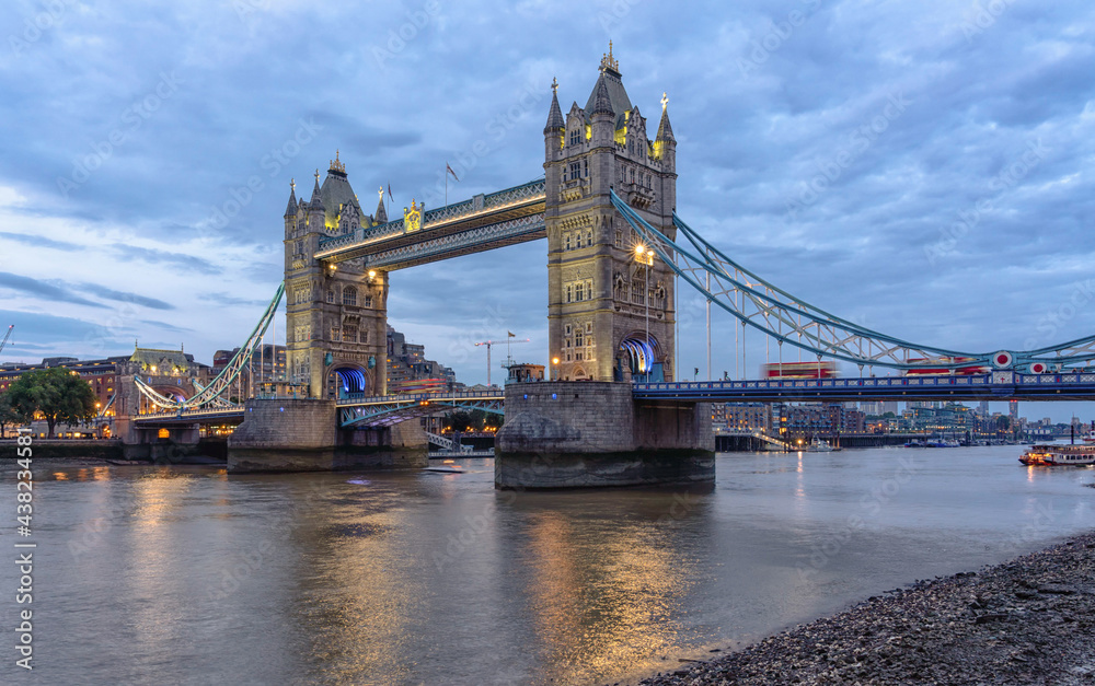 Tower Bridge London United Kingdom lit up at night with blue clouds over the Thames