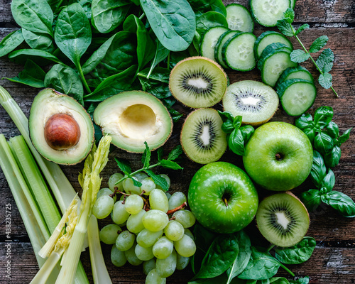 Overhead view of fresh green fruit and vegetables on a wooden table