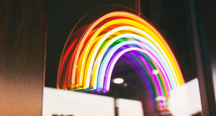 The led neon rainbow hanging on the door entrance in the cafe