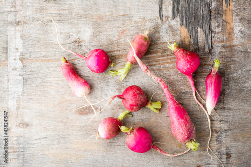 Fresh slightly overgrown radishes on a wooden table. Vegetables for a vegetarian diet. Rustic style. Top view