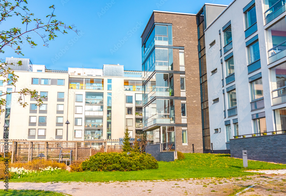 European residential complex of apartment buildings. Outdoor facilities. Eco-friendly living in a city. Modern block of flats. Scandinavian architecture. Green yard, trees, flowers. Helsinki, Finland European residential complex of apartment buildings. Outdoor facilities. Eco-friendly living in a city. Modern block of flats. Scandinavian architecture. Green yard, trees, flowers. Helsinki, Finland