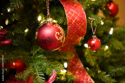 Christmas tree red ornaments and ribbbon. Close up photo