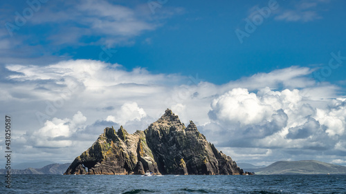 Cruise boat in front of Little Skellig island, habitat of Gannets, Morus Bassanus, with Irish coastline in the background, Ring of Kerry, Ireland photo
