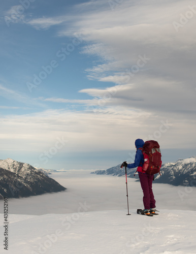 Hiker on top of a Mountain in Winter