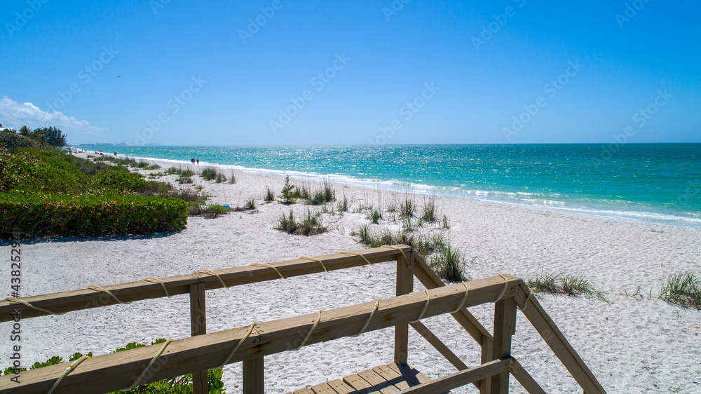 Natural beach with wooden walkway going to the sand