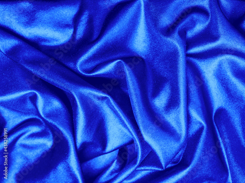 Texture background pattern Silk blue drapery. Beautiful wavy soft pleats on the surface satin fabric with copy space