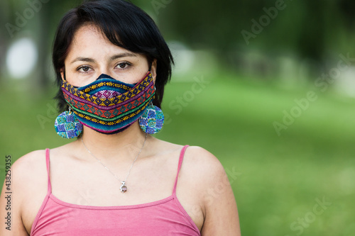 Latin America Bolivian woman with traditional pattern cloth mask. Handmade quechua native textile face mask for covid-19, coronavirus protection photo