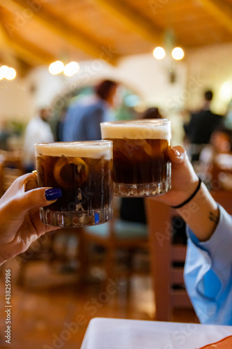 Hands toasting with beverage in restaurant