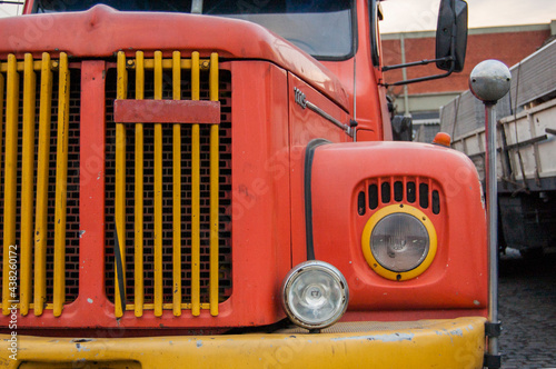 old orange and yellow truck with round headlights