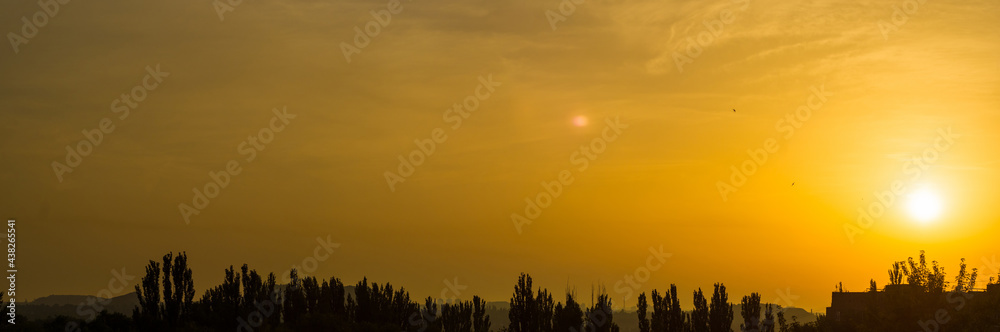 Fototapeta premium Landscape with dramatic light - beautiful golden sunset with saturated sky and clouds.